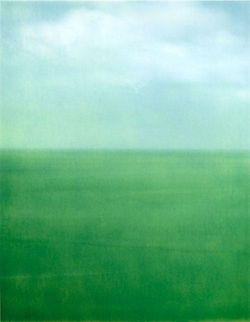 Soft green sea and a pale sky meeting at a distant horizon.