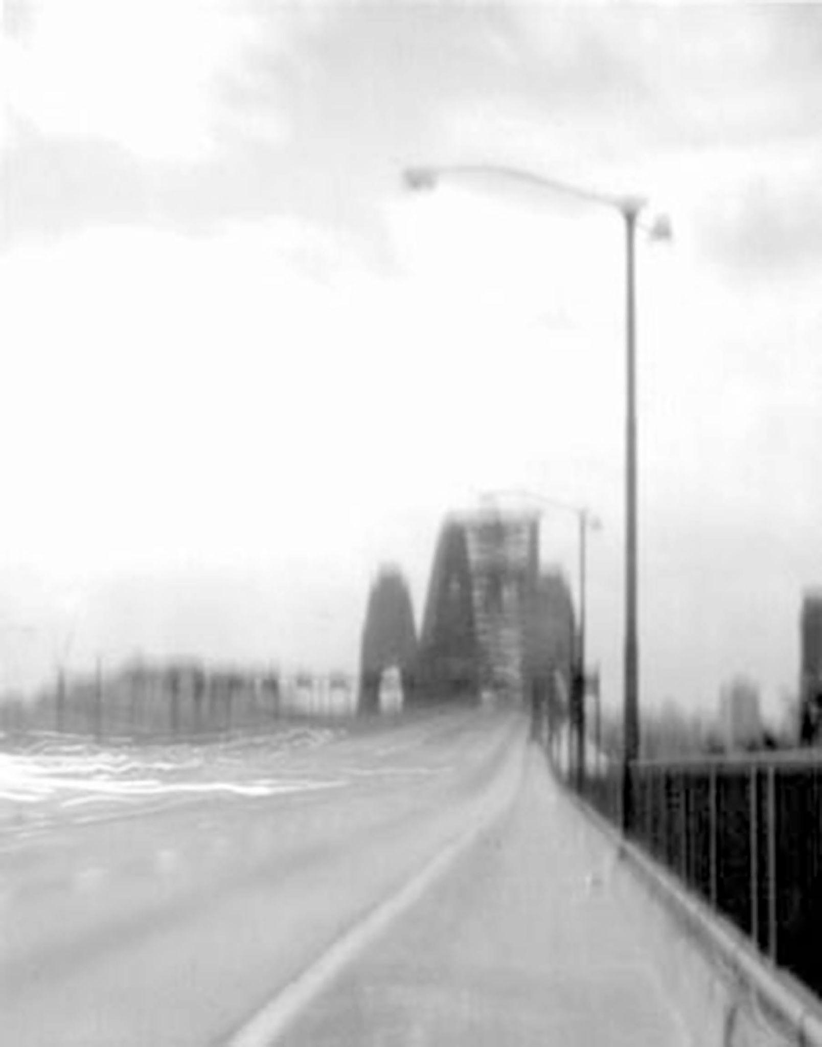Black-and-white pinhole photograph looking along the roadway towards the Sydney Harbour Bridge arch.